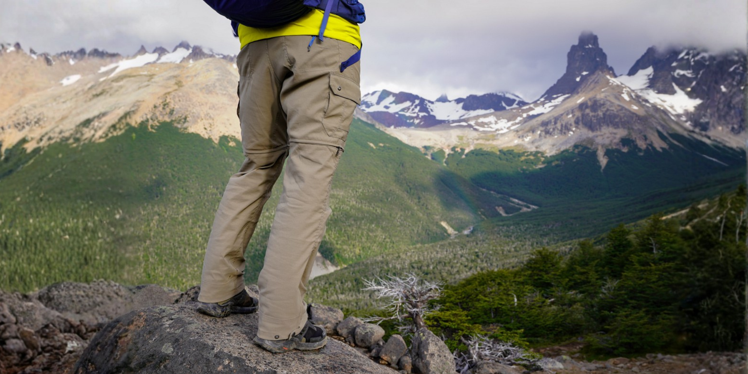 Person standing on a rocky outcrop with mountains in the background
